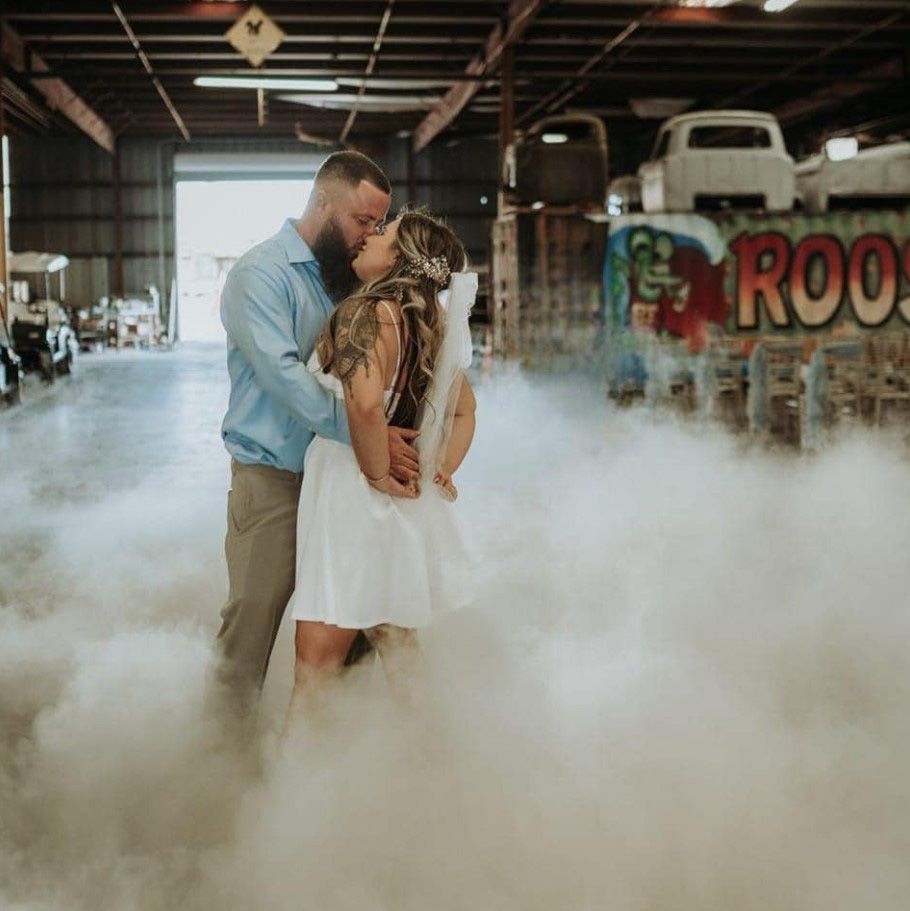 Image of a kissing couple in a short white wedding dress dancing with in the clouds